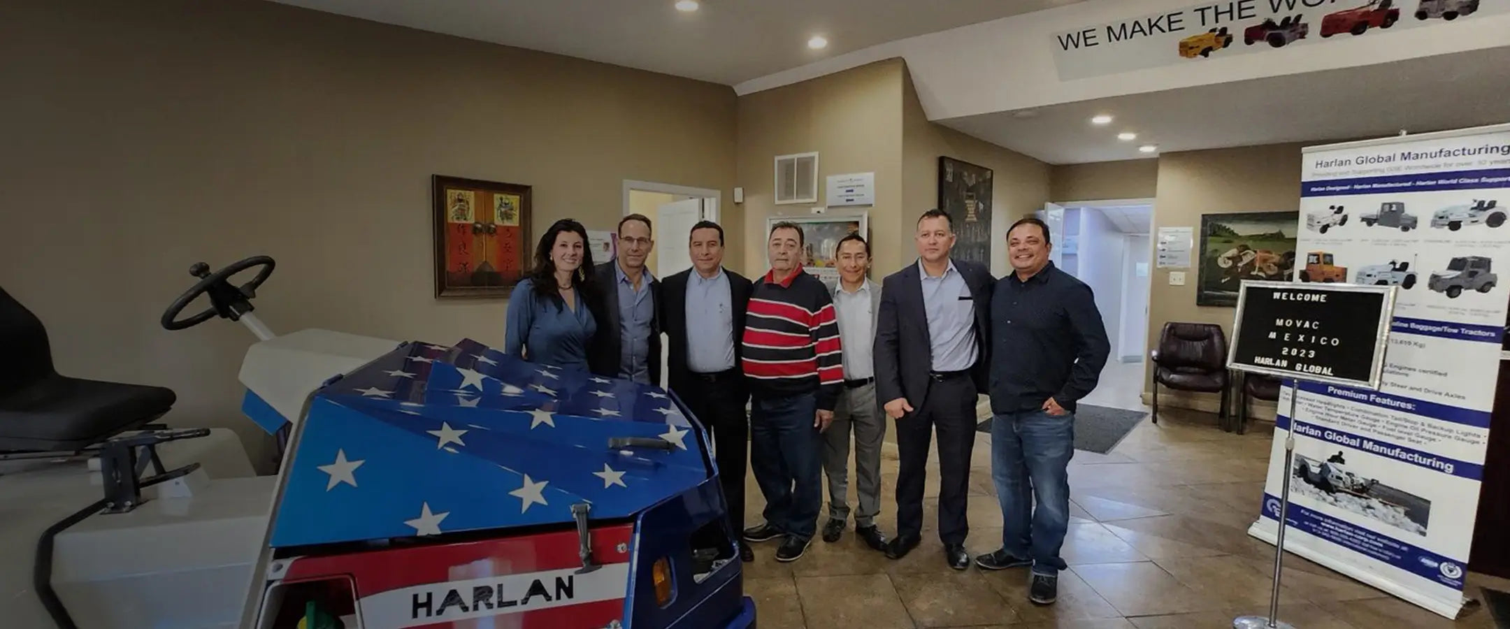 Harlan Global Manufacturing team standing in front of ground support vehicles.
